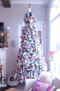 tall, skinny, flocked christmas tree with colorful ornaments by jennifer allwood