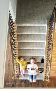 two daughters laying on stairs smiling