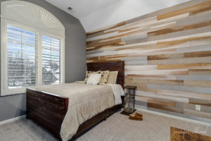 neutral bedroom with rustic decorations and a wood accent wall by jennifer allwood