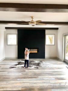 little girl smiling and posing in front of fireplace wall