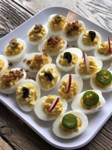 close up of deviled eggs with different garnishes on them