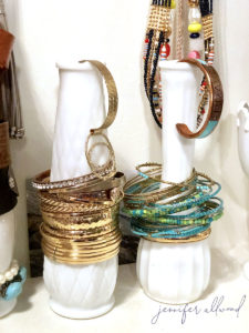 milk glass vases holding bracelets around them