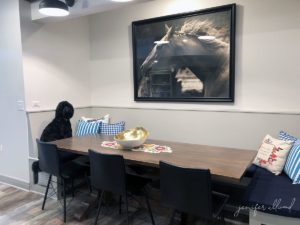 black goldendoodle seated at banquette table in basement